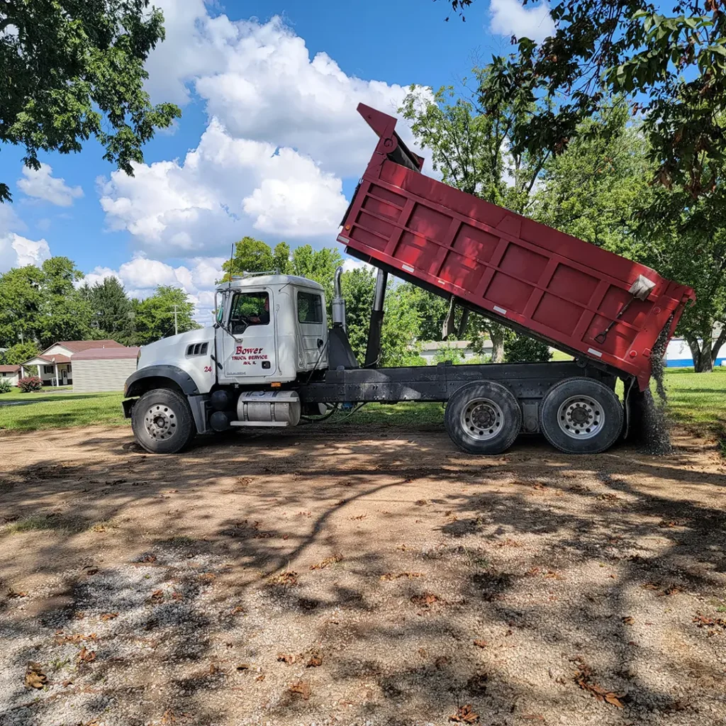 Truck spreading gravel professionally